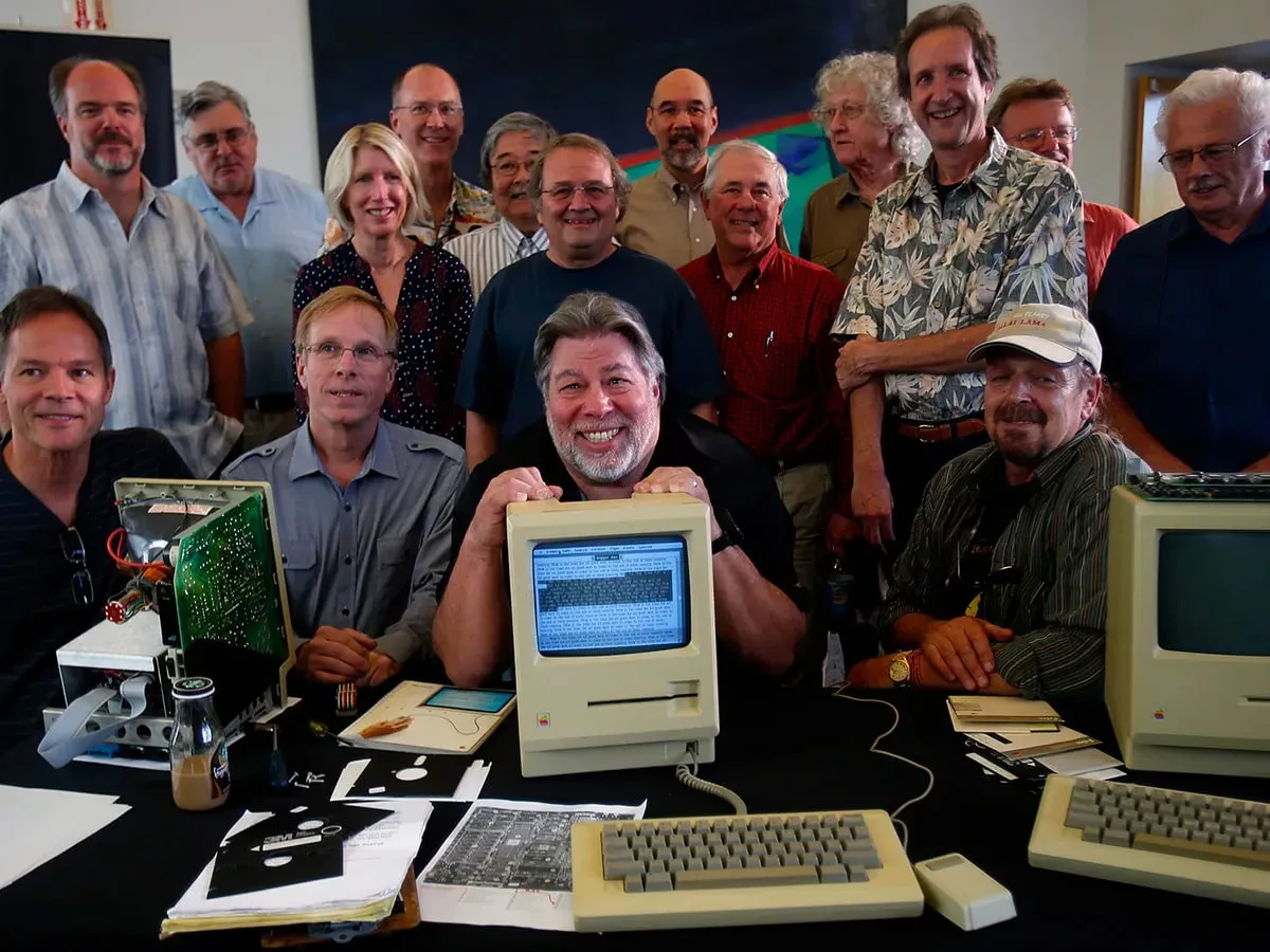 Groupe de personnes avec anciens ordinateurs Apple.