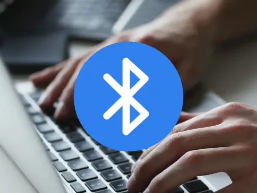 Mains tapant sur un clavier, logo Bluetooth.