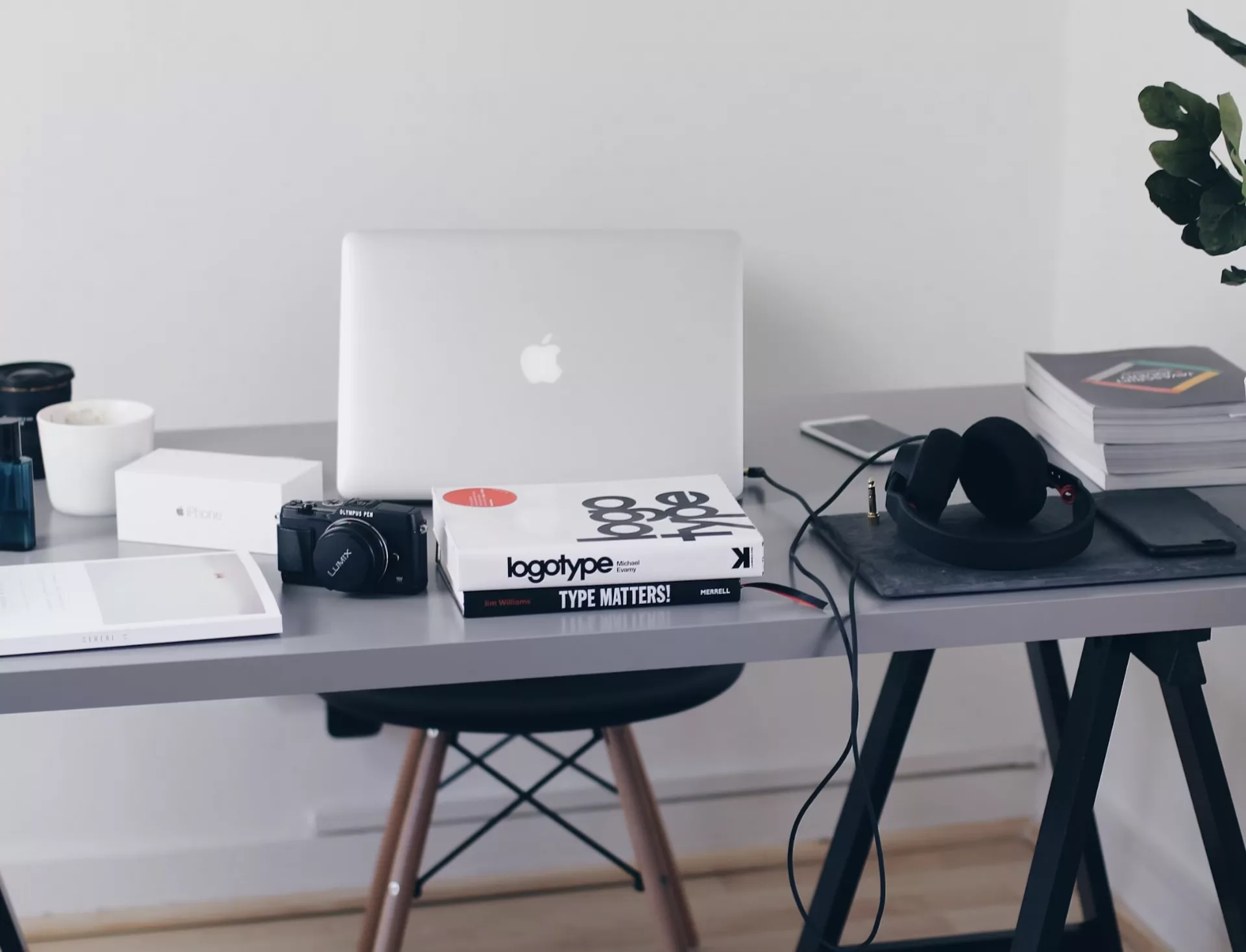 Bureau avec ordinateur, livres et accessoires divers.