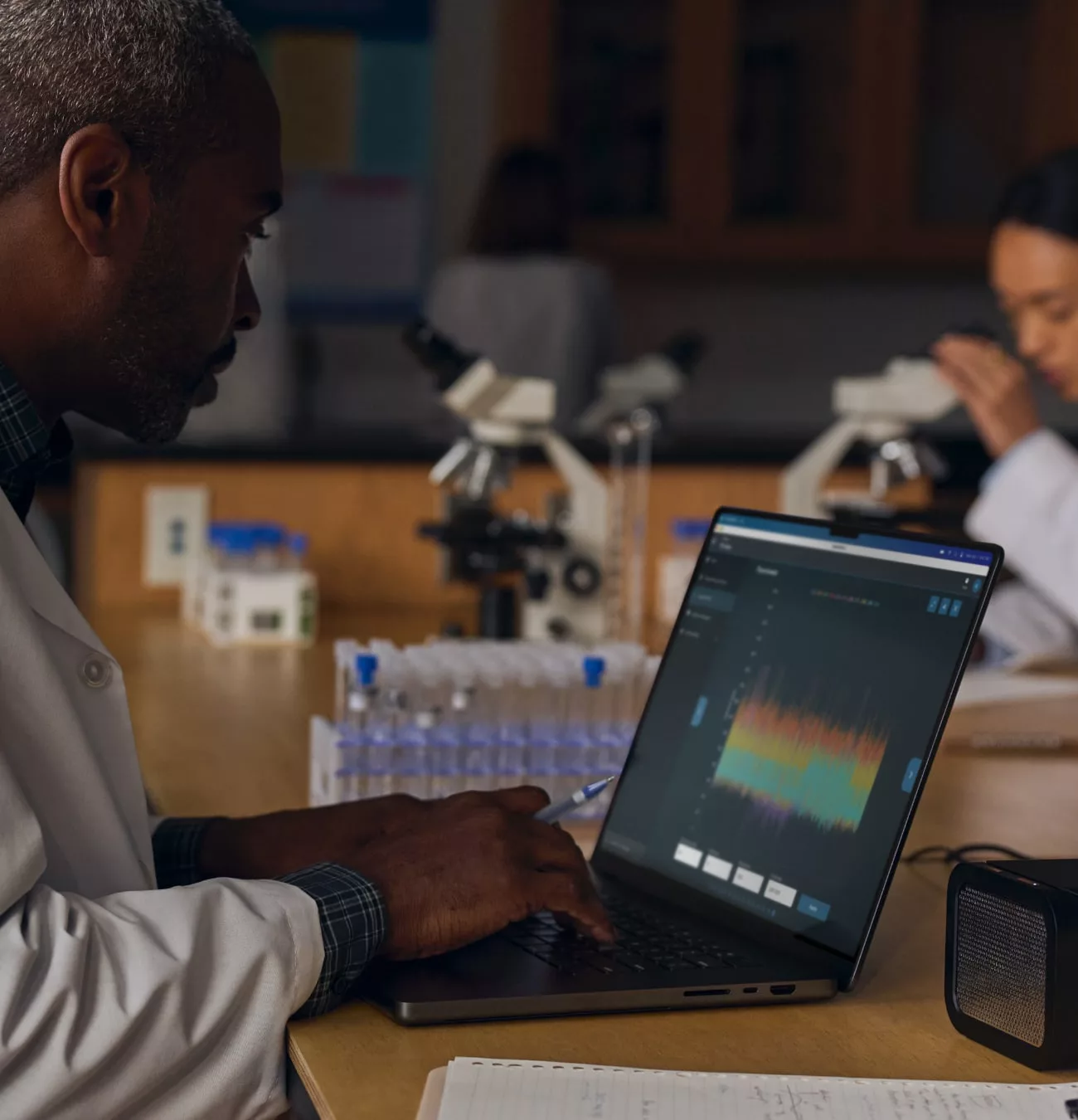 Scientifique analysant données sur ordinateur portable en laboratoire.