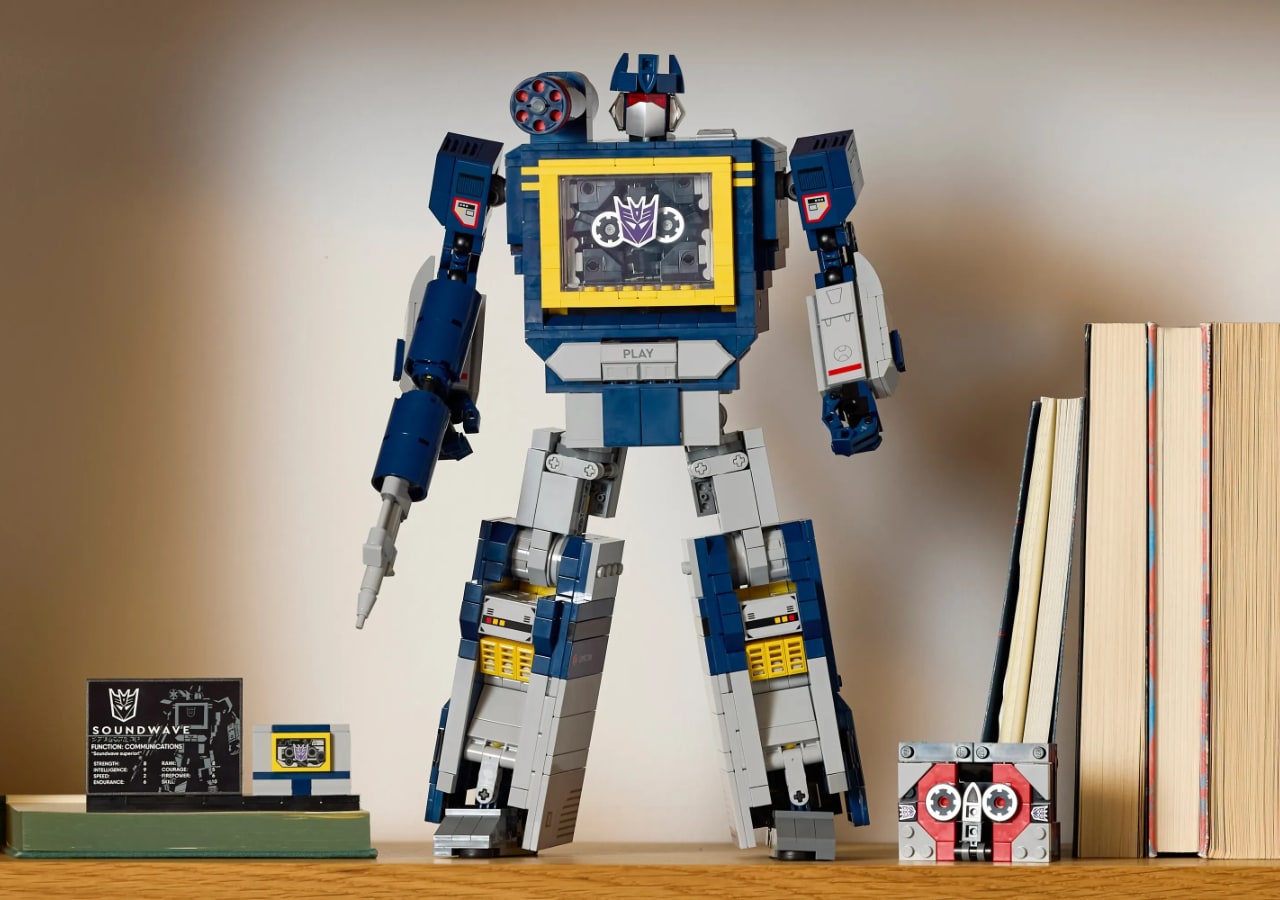 Figurine robot en briques sur étagère avec livres.