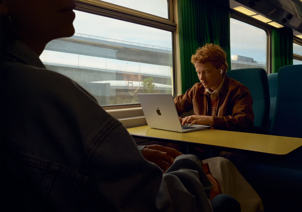 Personne travaillant sur un ordinateur dans un train. airpods pro 3