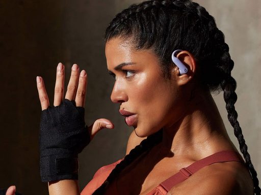 Femme avec écouteurs et gants, en train de boxer.
