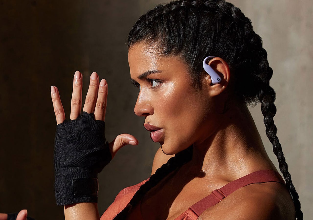 Femme avec écouteurs et gants, en train de boxer.