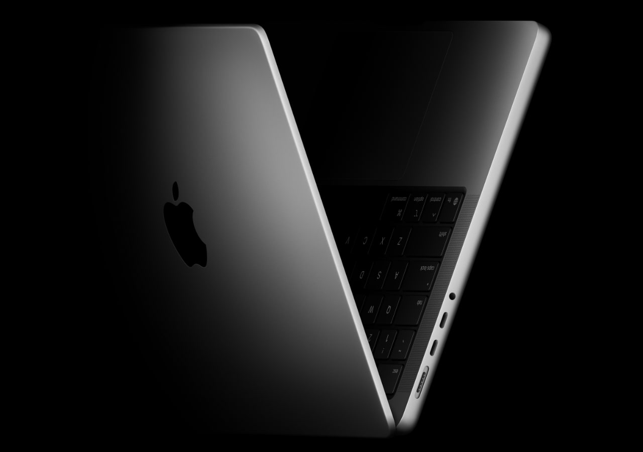 Ordinateur portable argenté ouvert partiellement, noir et logo visible.