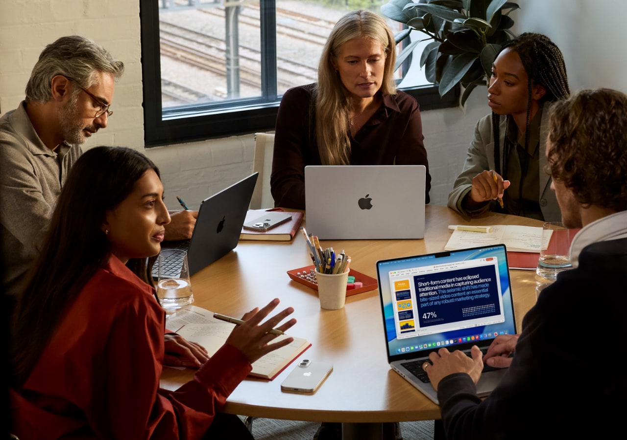 Groupe professionnel en réunion avec ordinateurs portables.