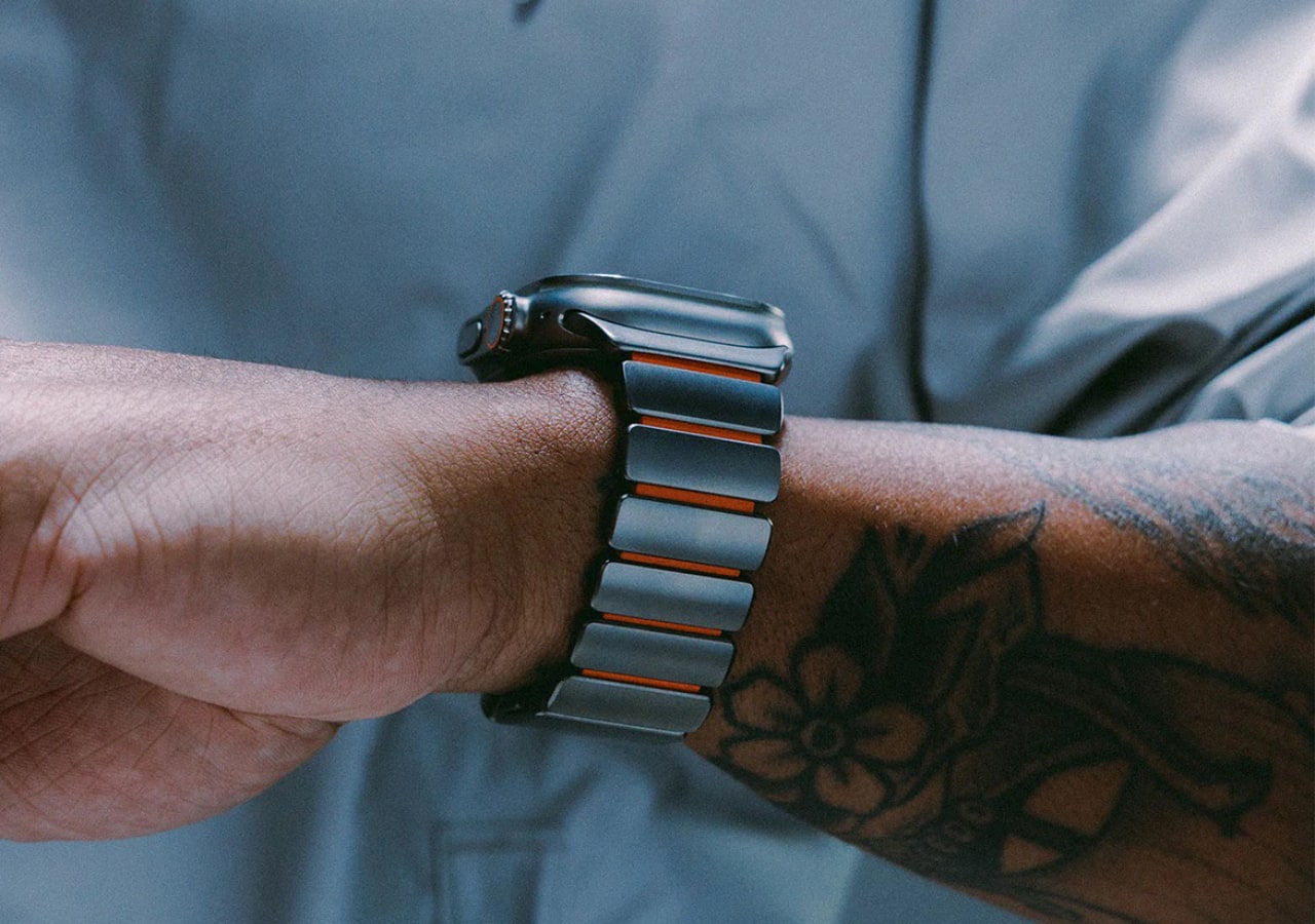 Bras tatoué portant une montre connectée moderne.