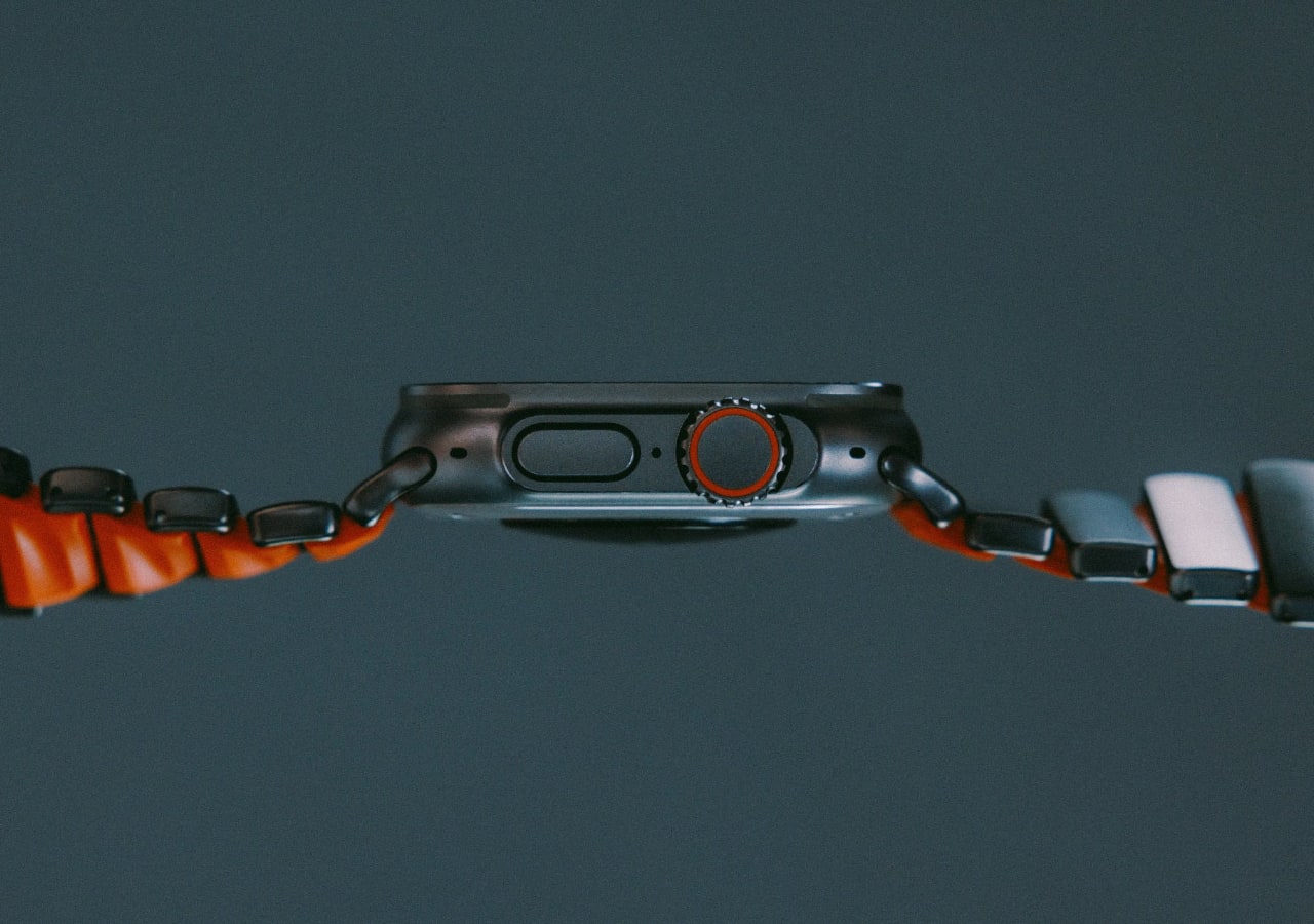 Vue latérale d'une montre connectée avec bracelet rouge.