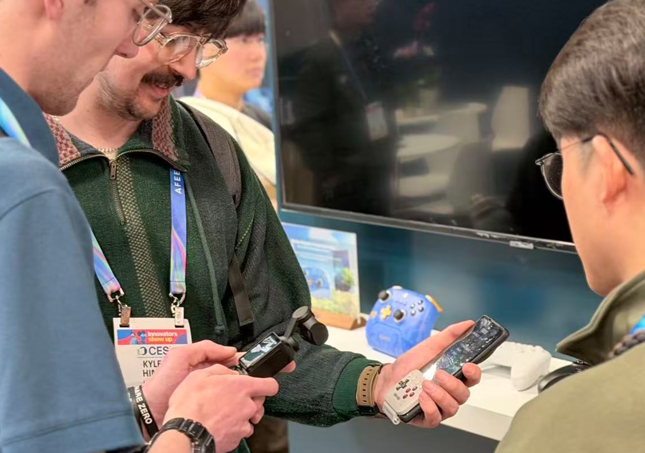 Personnes utilisant des gadgets lors d'un événement technologique.