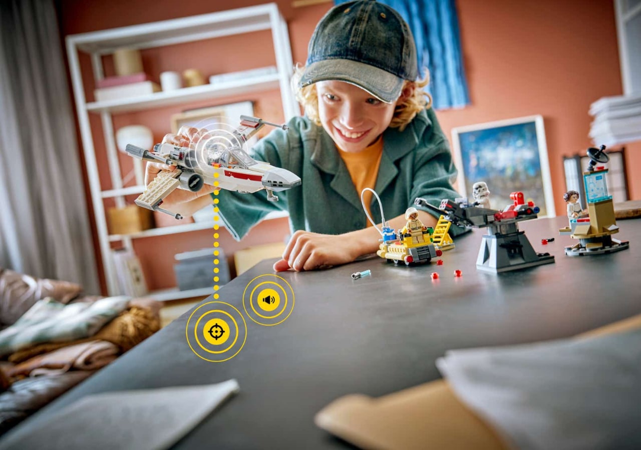 Enfant jouant avec des figurines et vaisseaux spatiaux LEGO.