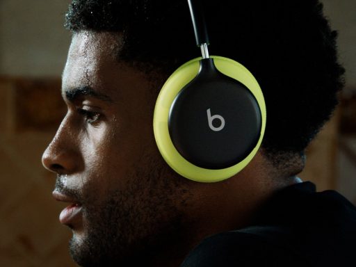 Sportif en sueur de profil portant un casque Beats 360 noir aux coussinets jaune volt